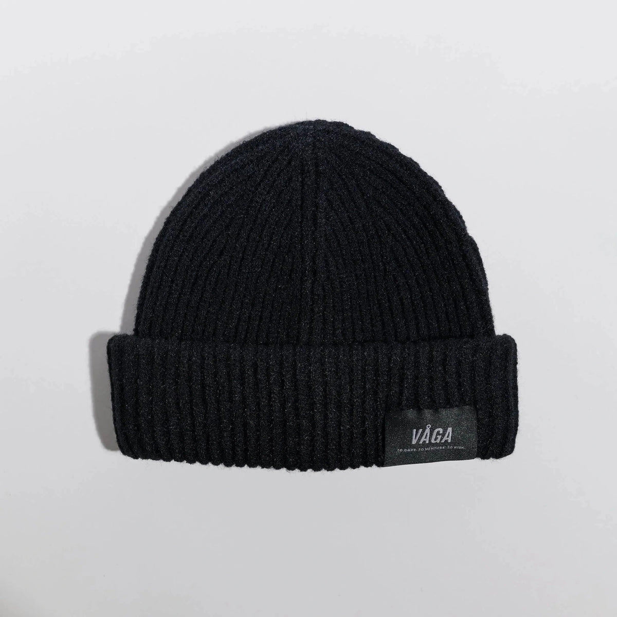Våga Midweight Beanie in zwart – plat neergelegd, voorkant met label