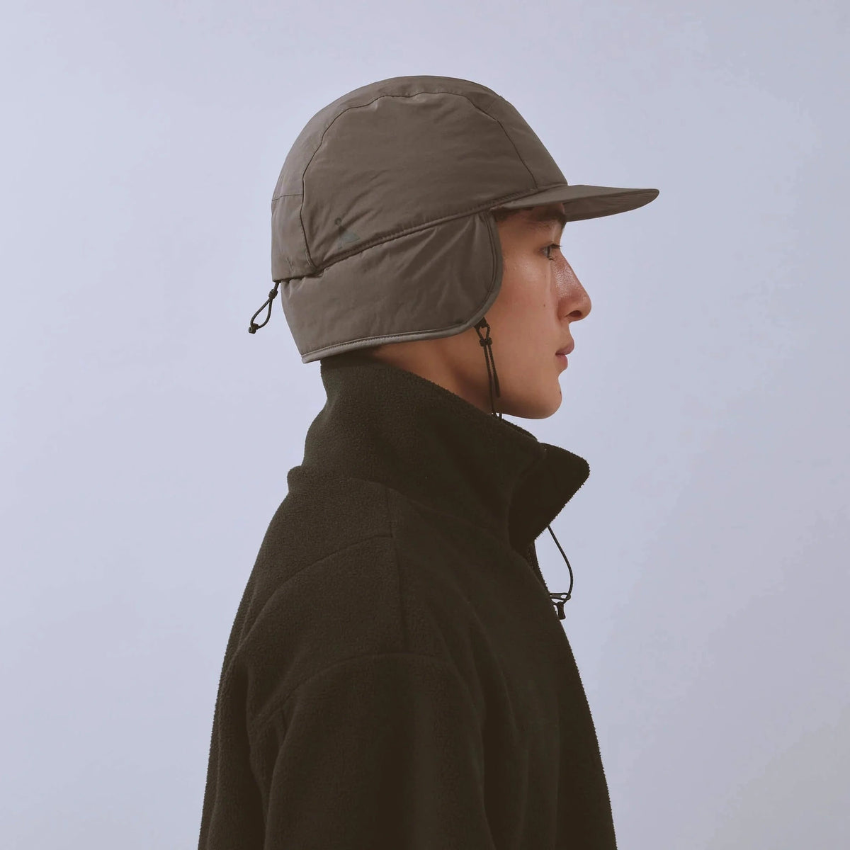 Vaga Padded Hiker Cap in grey – worn, side view with ear flaps down
