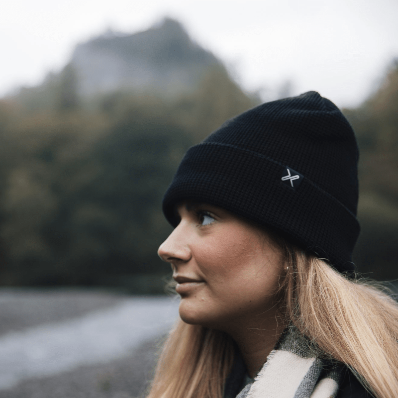 Extremities Contour Waterproof Beanie in zwart – gedragen door een vrouw buiten in de bergen