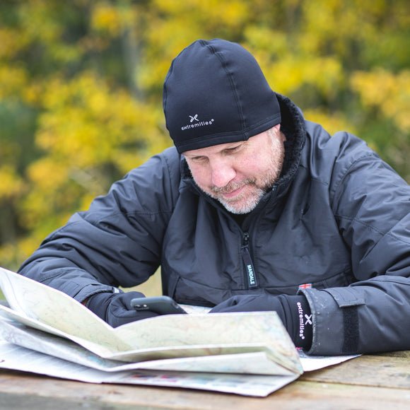 Extremities X-Therm Stretch Beanie in zwart – gedragen door een man die buiten een kaart leest