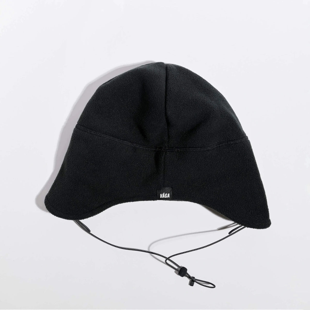 Våga Fleece Summit Beanie in zwart – plat neergelegd, achterkant met label
