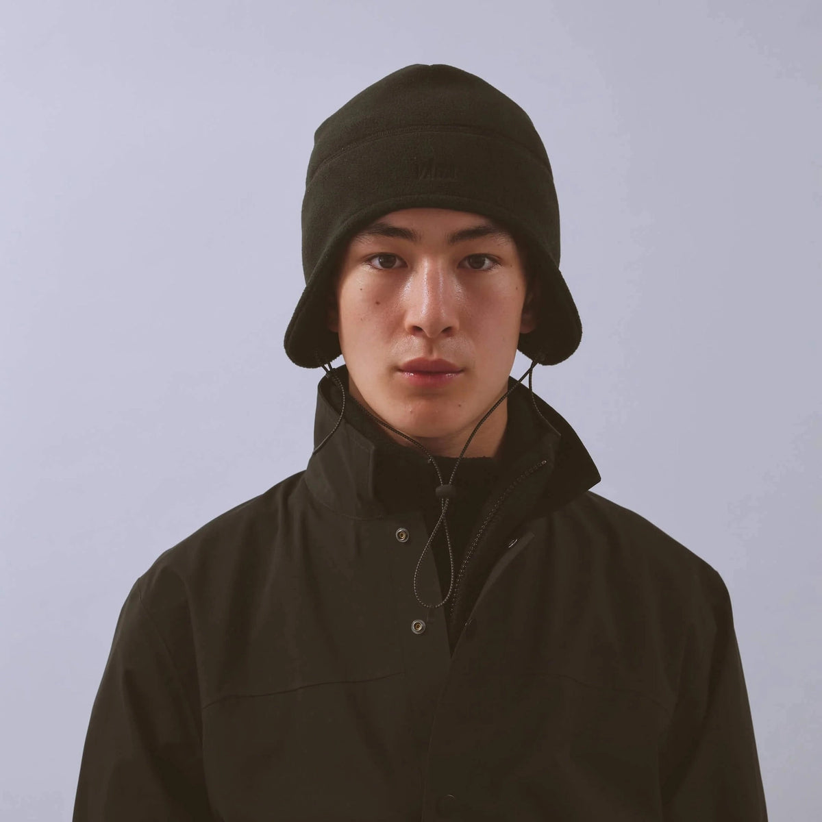 Våga Fleece Summit Beanie in zwart – gedragen, vooraanzicht met oorflappen