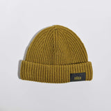 Våga Midweight Beanie in mosgroen – plat neergelegd, voorkant met label