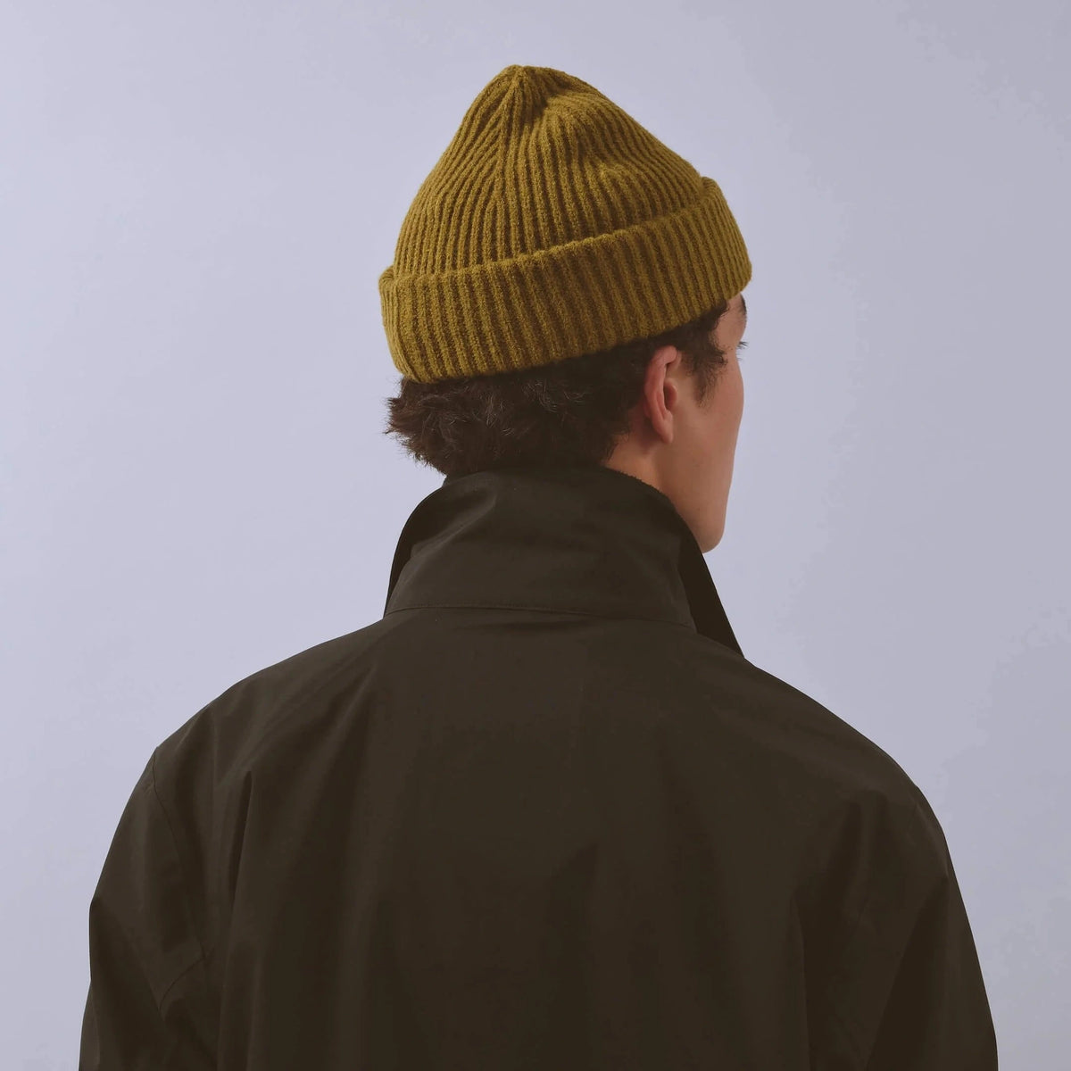 Våga Midweight Beanie in mosgroen – gedragen, schuin achteraanzicht