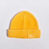 Våga Midweight Beanie in geel – plat neergelegd, voorkant met label