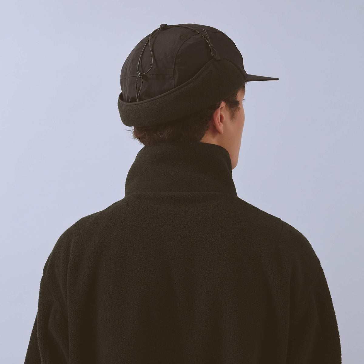Vaga Padded Hiker Cap in black – worn, rear view with ear flaps up