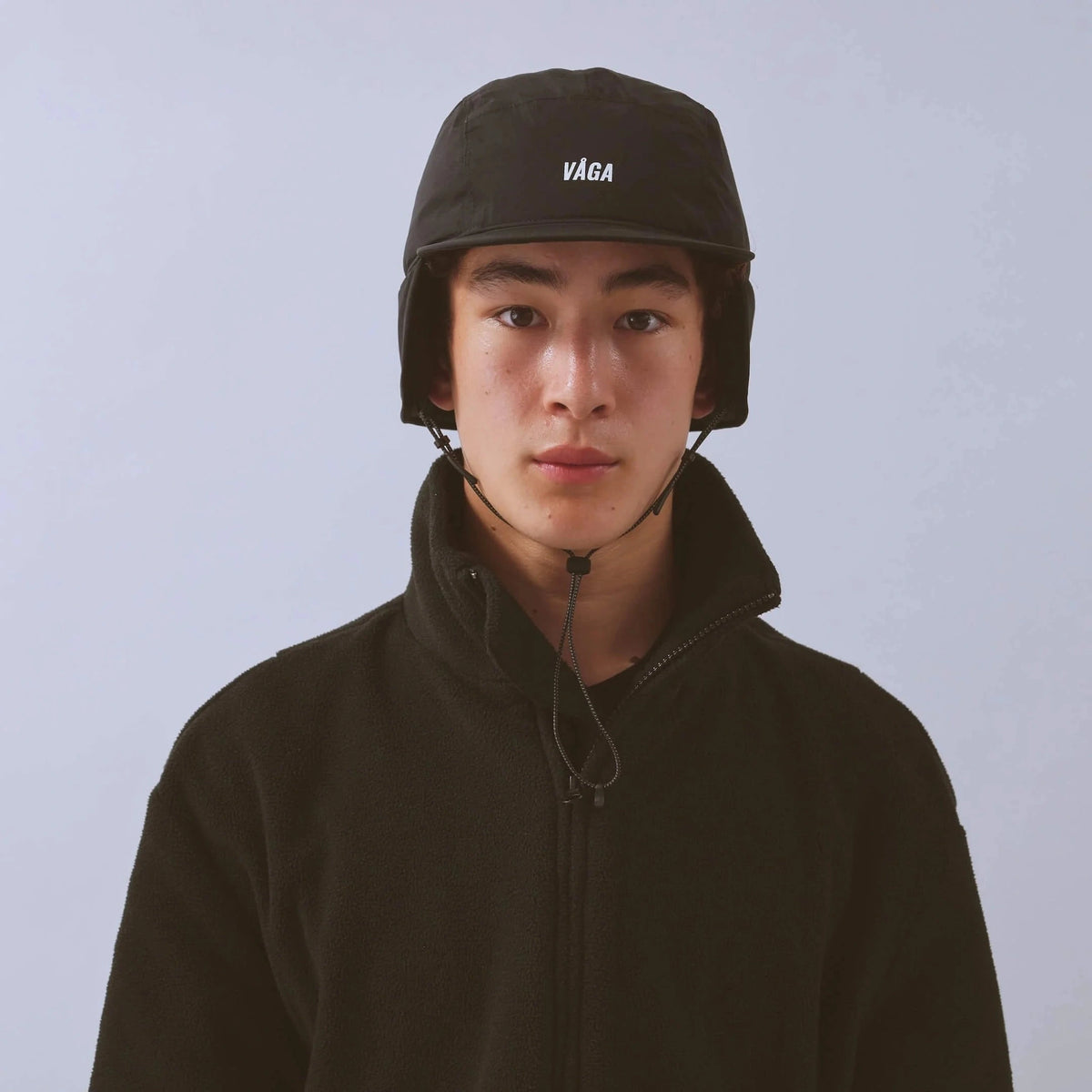 Vaga Padded Hiker Cap in black – worn, front view with ear flaps down
