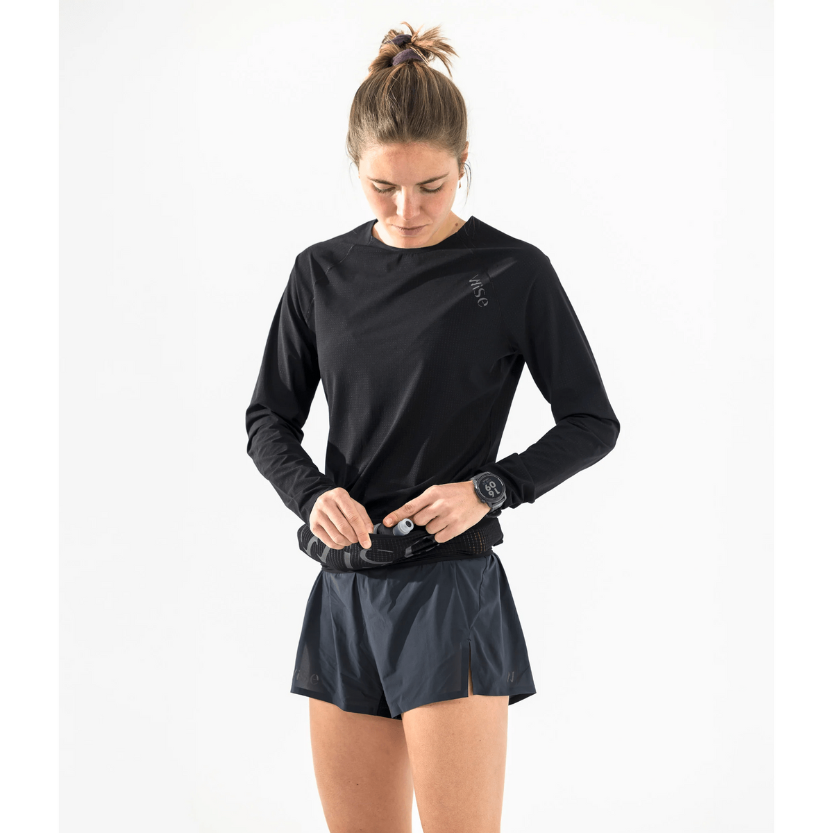 Wise Sherpa Hydration Belt in zwart – vrouw maakt de belt vast om haar heupen